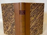 un vieux livre posé sur une table recouverte d'un tissu blanc