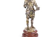 une image représentant une statue d'un homme tenant une épée, posée sur un socle en bois