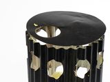 a black trash can with holes in it on a white surface