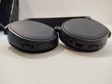 two black headphones sitting on a table next to a cell phone