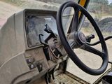 a steering wheel and dashboard of a truck on a dirt road
