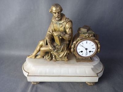 une statue représentant un homme assis sur un banc à côté d'une horloge
