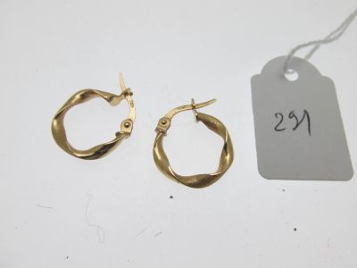 une paire de boucles d'oreilles créoles en or avec une étiquette de prix