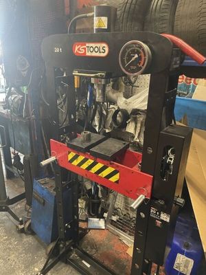un gros plan sur une machine dans un garage, avec un pneu en arrière-plan