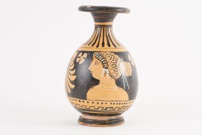 a black and gold vase with an image of a woman on it