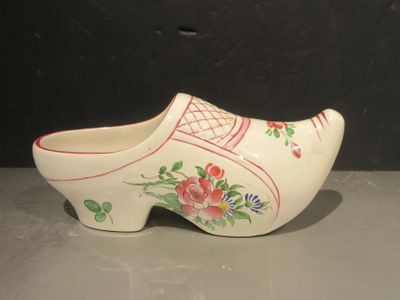 un sabot en bois blanc orné de fleurs rouges et roses