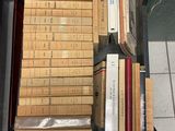 a suitcase full of books sitting on a tiled floor