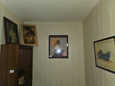 une photo d'un couloir avec des tableaux accrochés au mur