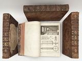 an open book sitting on top of a table next to a book