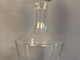 une image représentant une bouteille en verre transparent surmontée d'un oiseau