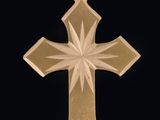 pendentif en forme de croix en or avec un motif en forme d'étoile rayonnante sur fond noir