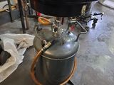 une grande casserole en métal posée sur une bonbonne de propane