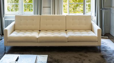 a white couch sitting in front of a window in a living room