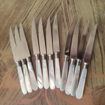 six couteaux sont alignés sur une table