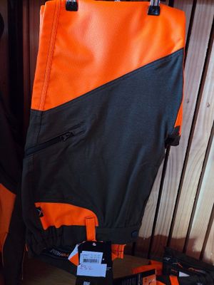an orange and black backpack sitting on a shelf next to a pair of shoes