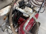 a red motorcycle with a hose attached to the back of it