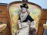 a doll that is sitting on a chair in a room