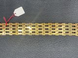 a close up of a gold bracelet with a tag attached to it