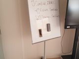 a white board with writing on it next to a monitor