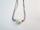 collier composé d'une perle blanche et d'une chaîne en argent, sur un fond blanc