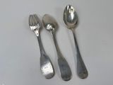 three spoons and two spoons sitting on a table