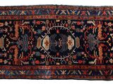 un tapis persan ancien orné d'un motif bleu et rouge sur fond blanc