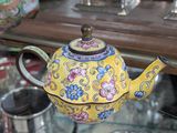 une théière jaune posée sur une table en verre