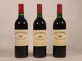 trois bouteilles de vin rouge posées côte à côte sur une table