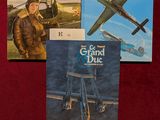 trois livres sont posés sur une nappe rouge, sur une table