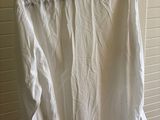 a white shirt hanging on a hanger in front of a window