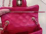 someone is holding a pink purse with a chain hanging from it