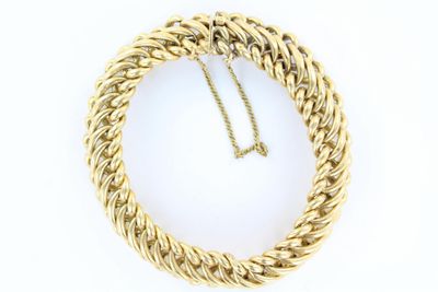 gros plan d'un collier en or sur fond blanc