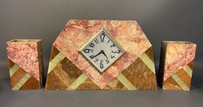 a clock sitting on top of a table next to two vases