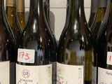 plusieurs bouteilles de vin sont alignées sur une étagère