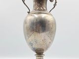 an antique silver vase on a white surface with a white background