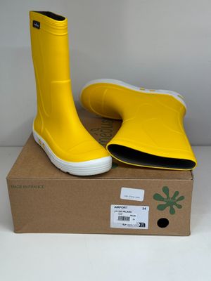 une paire de bottes de pluie jaunes posée sur une boîte en carton