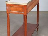 an old wooden table with a marble top in a room