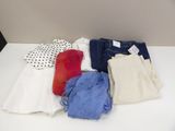 a white table topped with lots of clothes on it