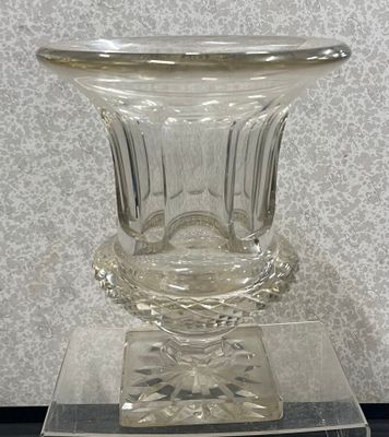 un vase en verre posé sur un socle transparent