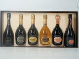 cinq bouteilles de vin dans un coffret en bois posé sur une table