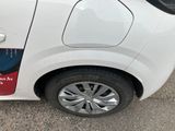 a small white car parked on the side of the road