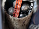 a bucket full of metal balls with a tag in it
