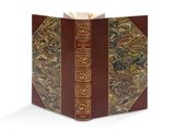 un vieux livre à la couverture brune et à la bordure dorée