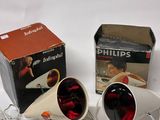 pair of white lamps with red lights and a box on a white surface