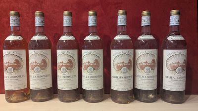 six bouteilles de vin sont alignées sur une table