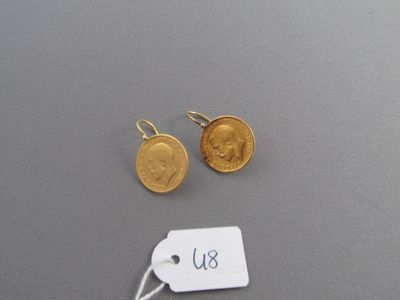 deux pièces d'or et une étiquette sur une surface grise