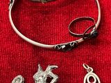 un collier, un bracelet et une bague posés sur un tissu rouge