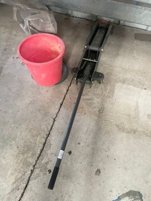 un seau d'eau posé par terre à côté d'un poteau