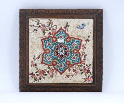 un carreau encadré orné d'un motif floral et d'un oiseau