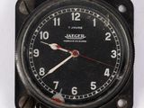 une horloge noire avec une trotteuse rouge sur un fond blanc